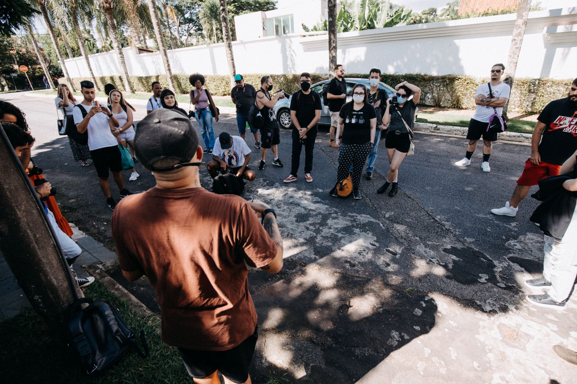 A diverse group of people on a guided tour during a sunny day on an urban street.